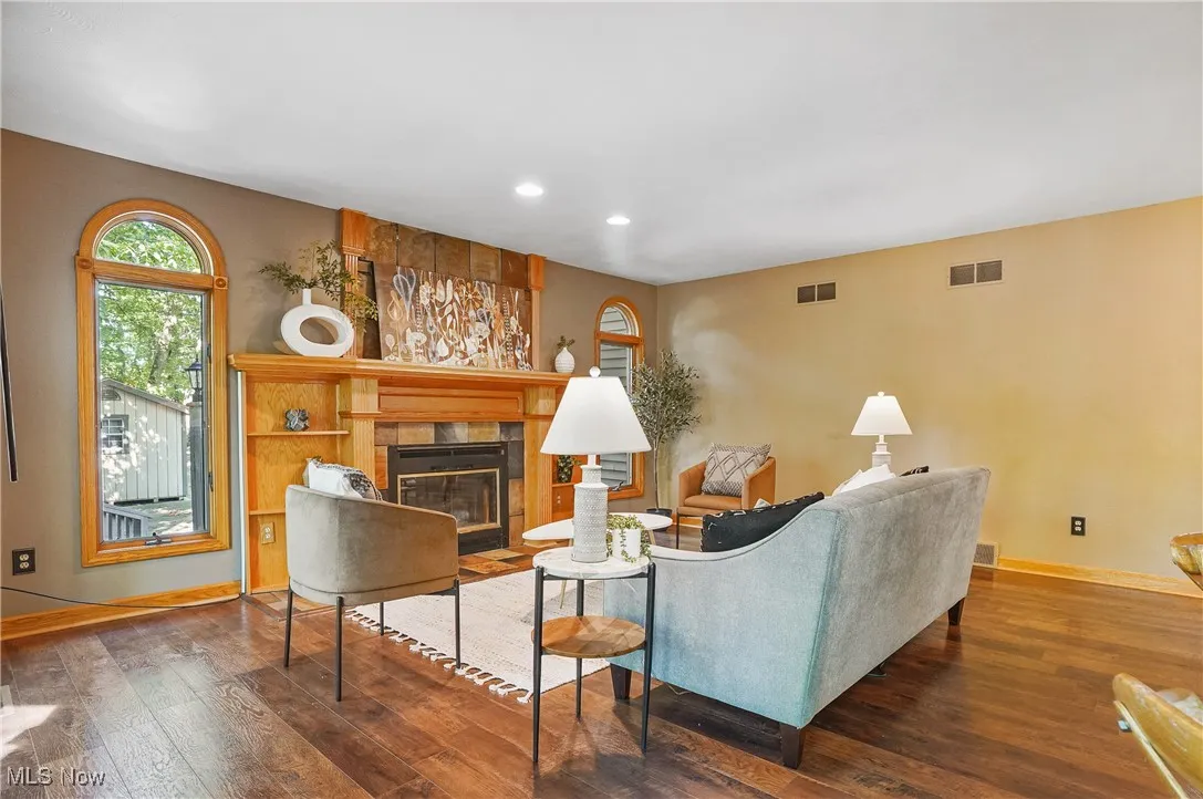 Living room featuring a tiled fireplace, recessed lighting, and hardwood / wood-style flooring