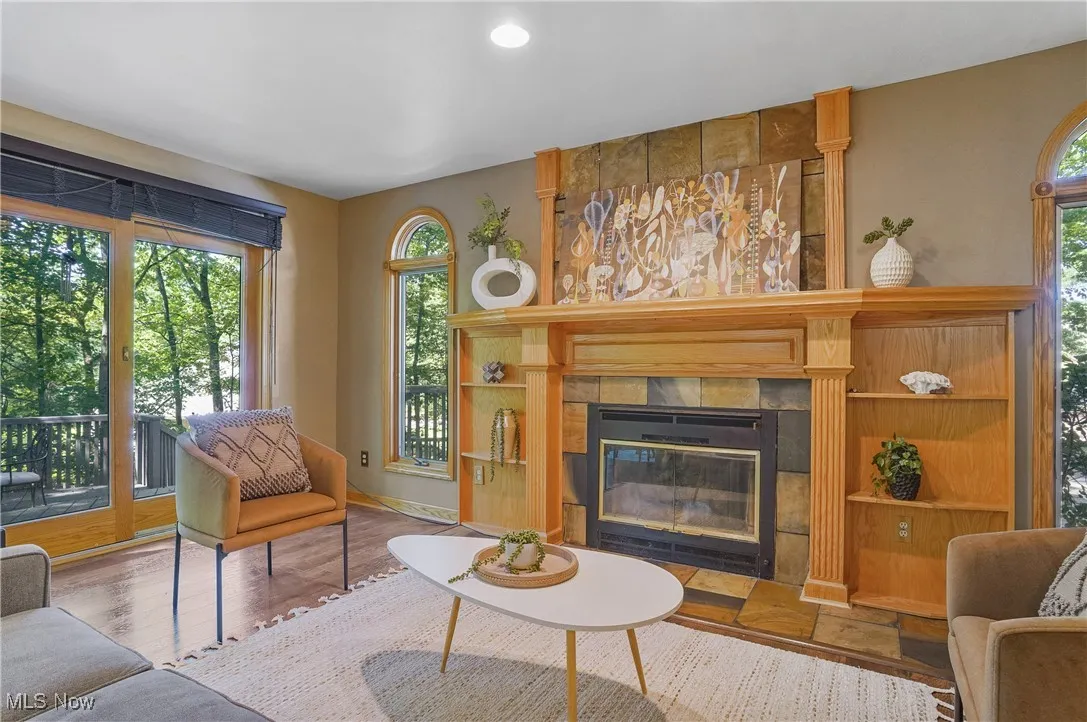 Living room featuring healthy amount of natural light, a tile fireplace, and wood finished floors