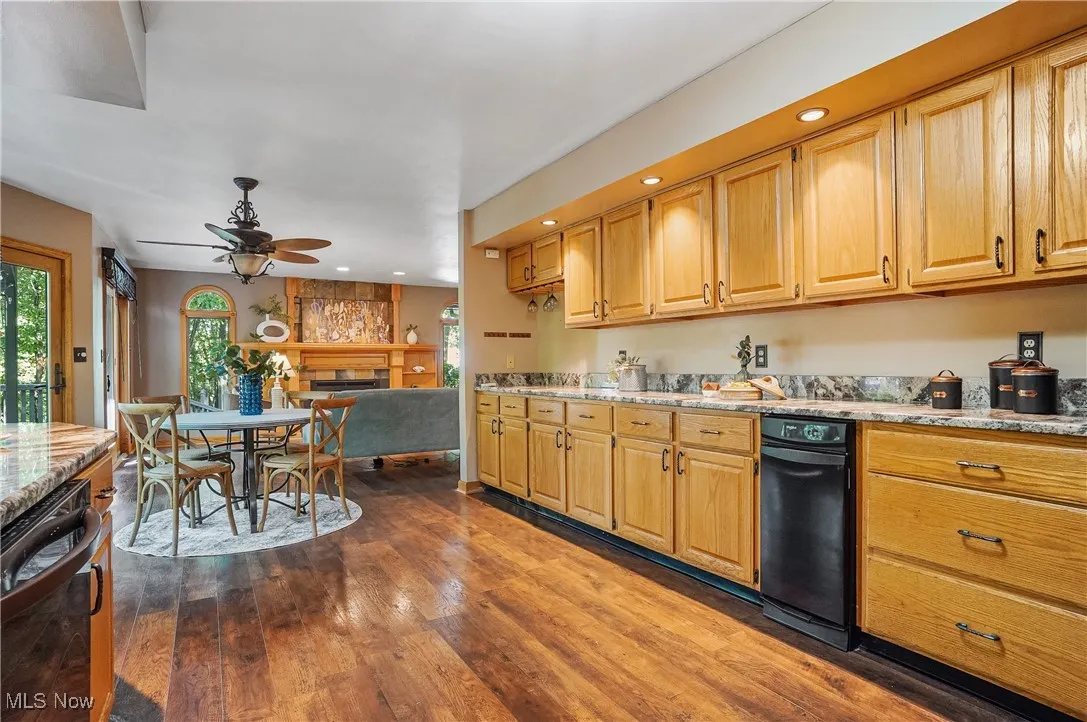 Kitchen with ceiling fan, recessed lighting, dark wood finished floors, and light stone countertops