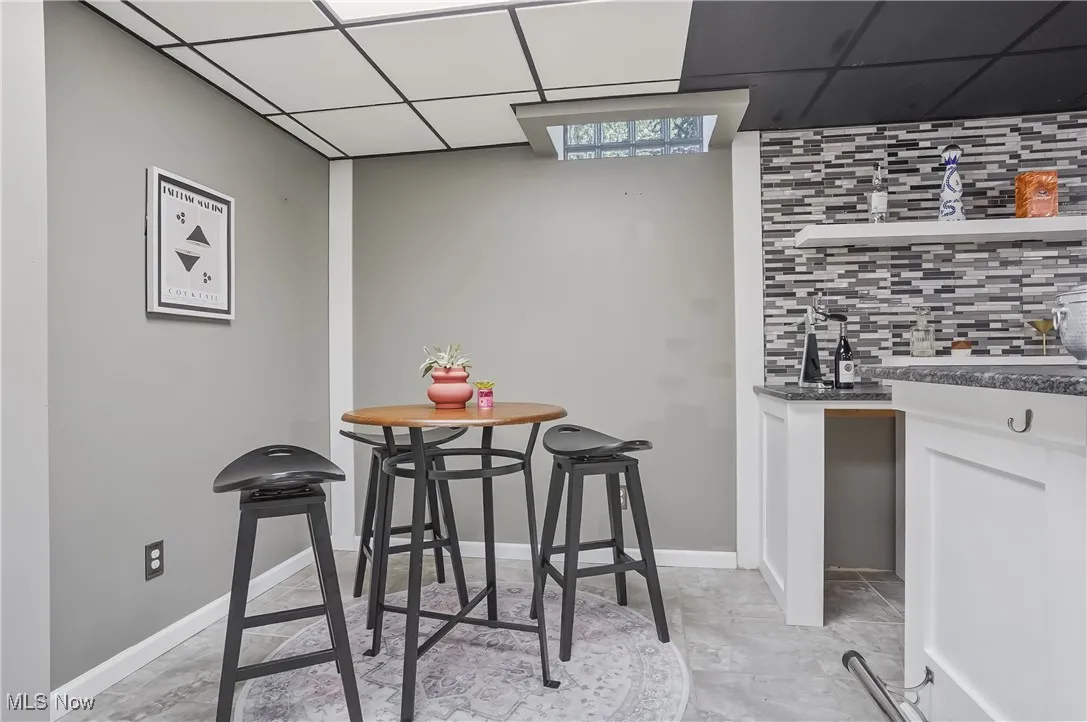 Dining area with wet bar and a paneled ceiling