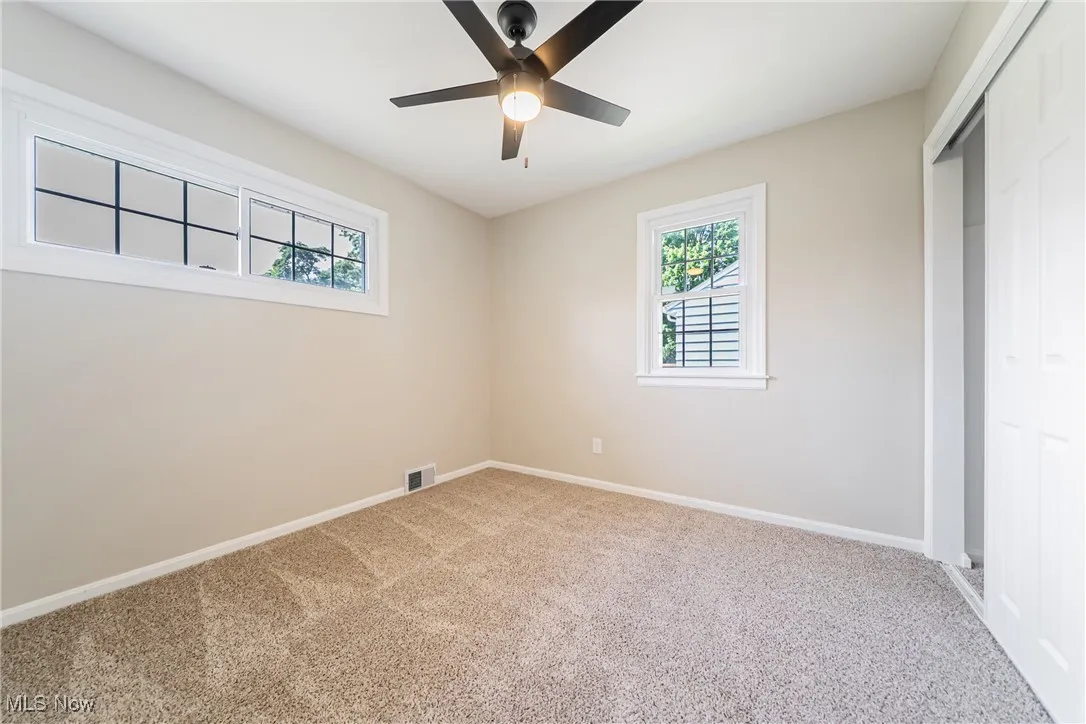 Unfurnished bedroom with carpet flooring, a closet, and a ceiling fan