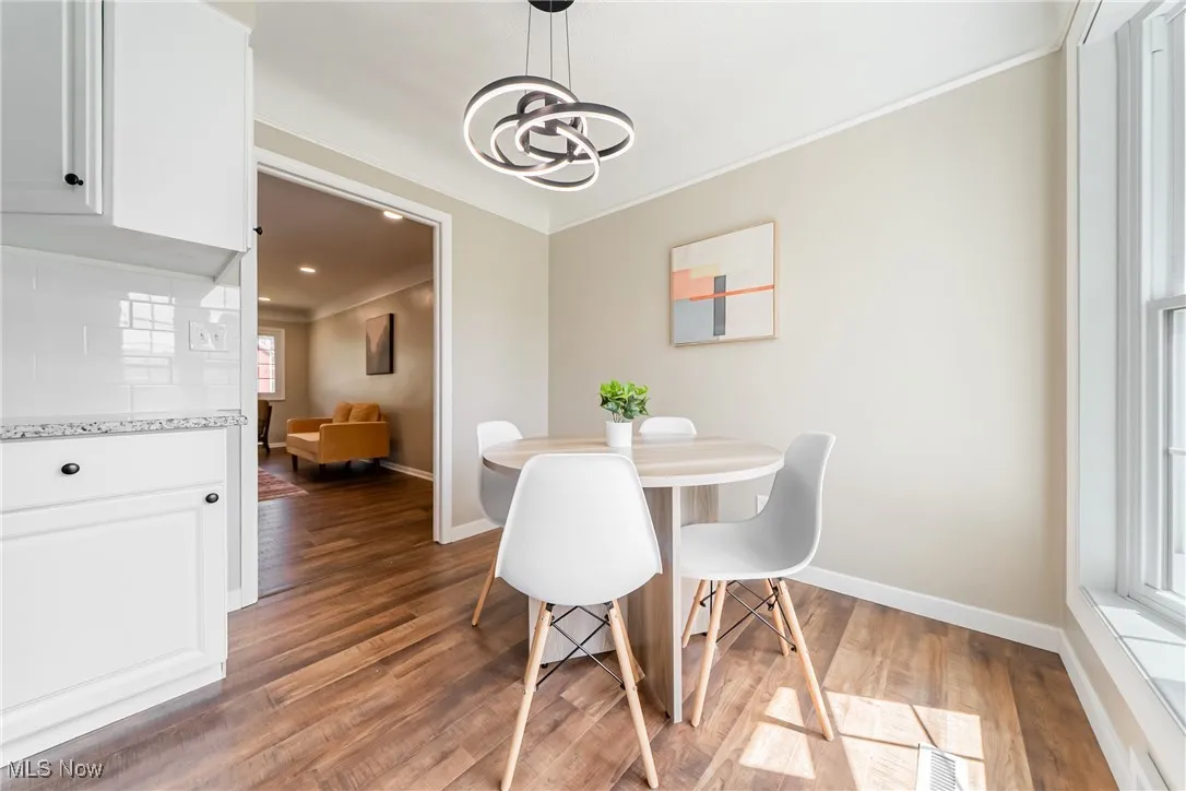 Dining room featuring ornamental molding, a chandelier, and wood finished floors