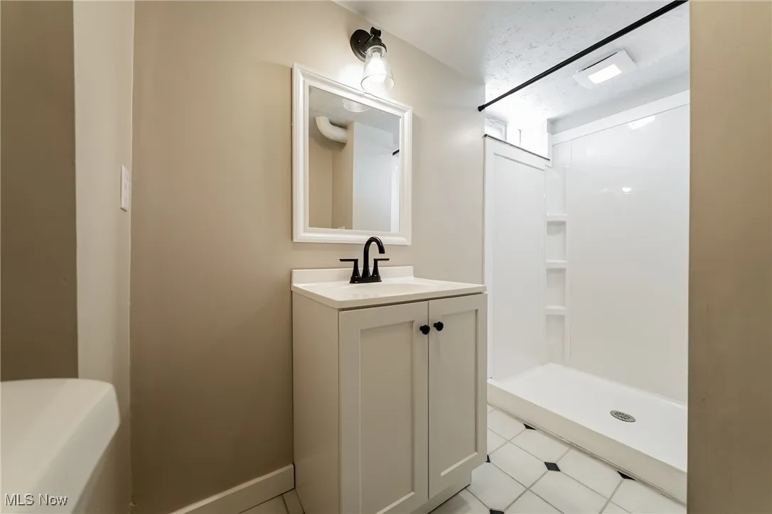 Full bathroom featuring vanity and a stall shower