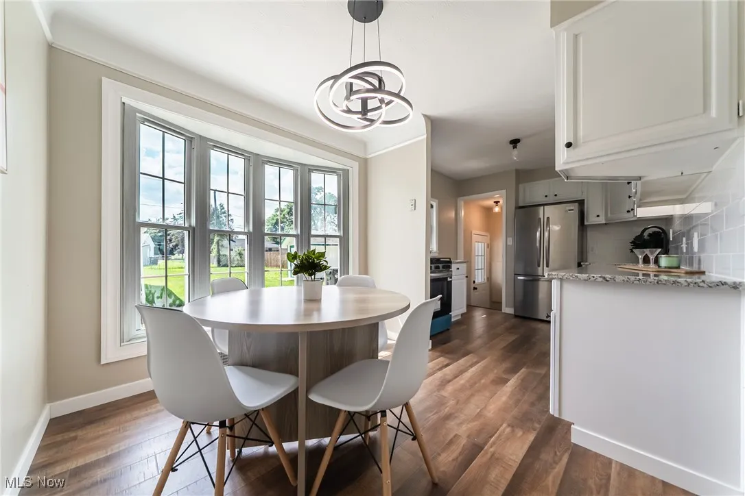 Dining area with dark wood-style floors and a chandelier