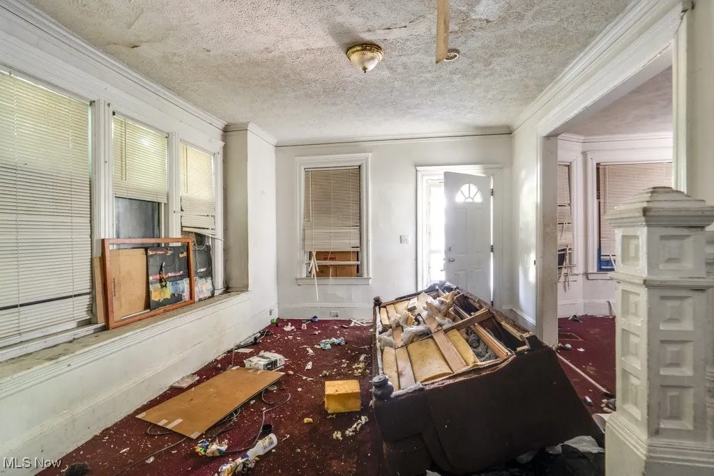 Foyer with a textured ceiling and ornamental molding