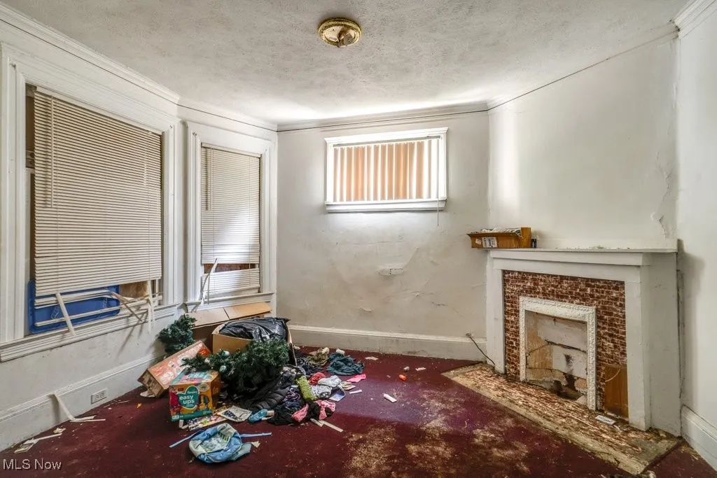 Unfurnished living room featuring a textured ceiling and a tiled fireplace