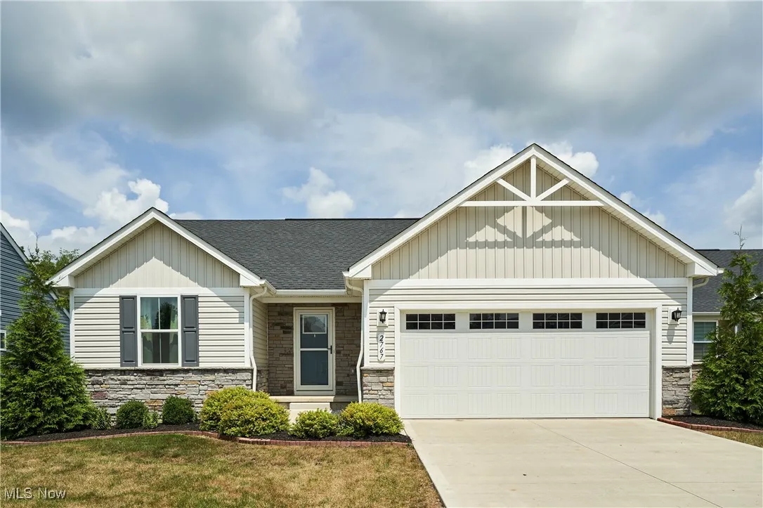 Craftsman inspired home with stone siding, concrete driveway, board and batten siding, and a shingled roof