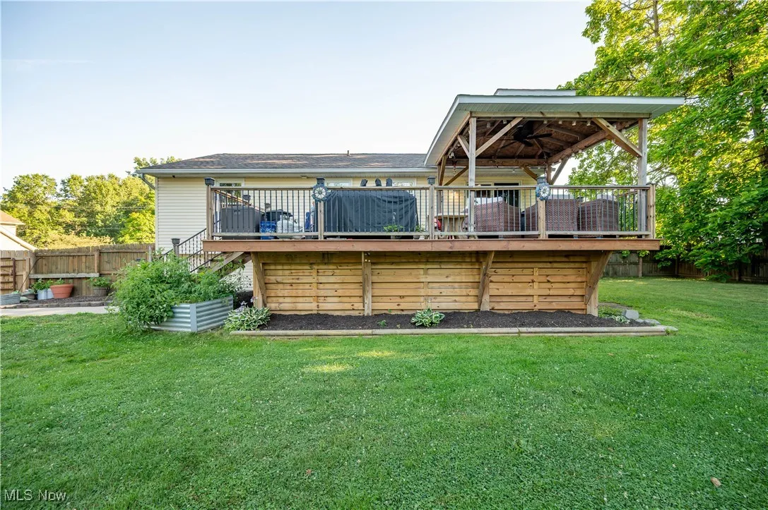 Back of property with stairs and a deck
