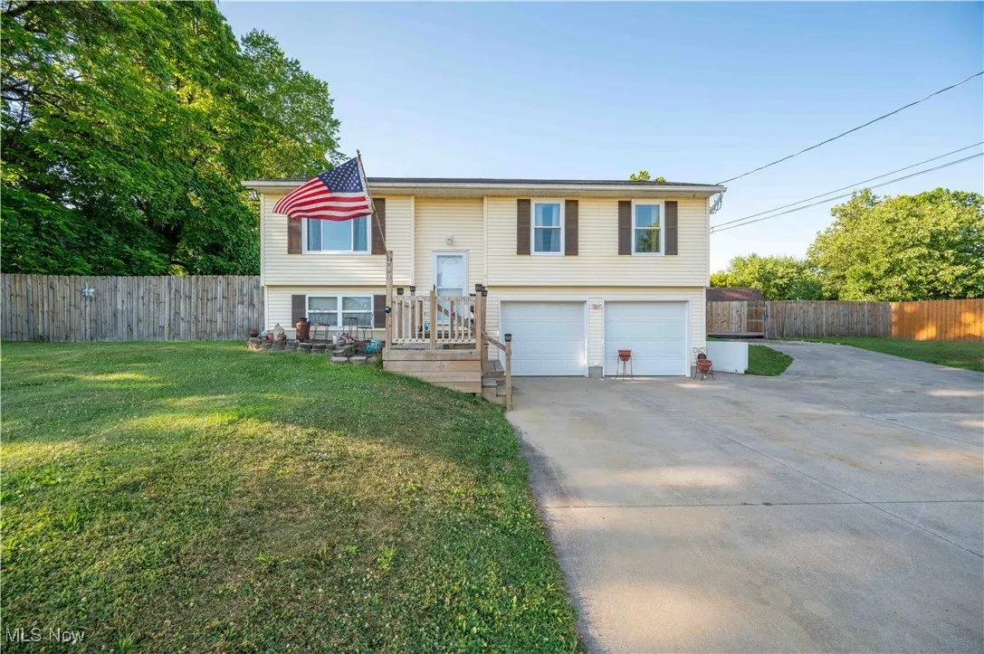 Bi-level home featuring concrete driveway and an attached garage
