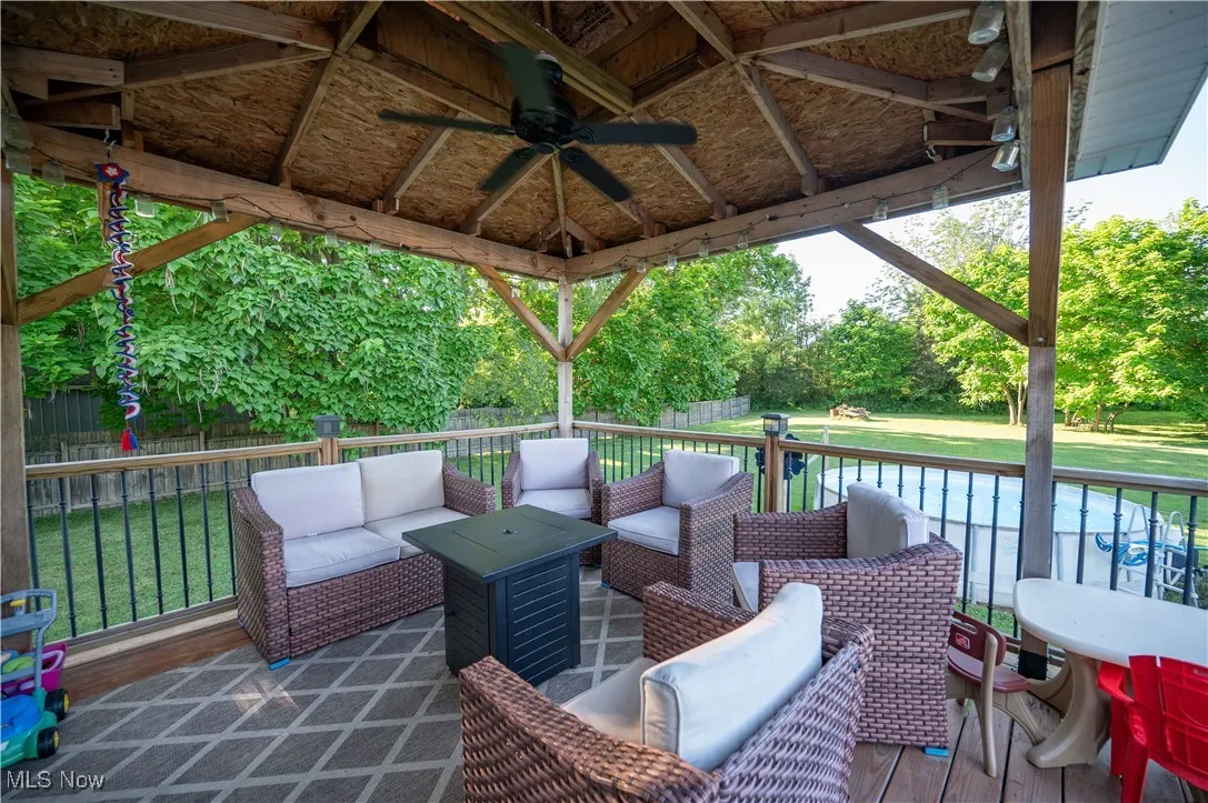 Deck featuring a ceiling fan, an outdoor hangout area, a gazebo, and a fenced backyard