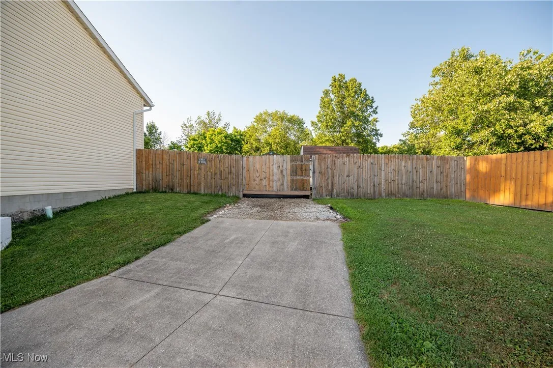 Fenced yard with a gate and a patio