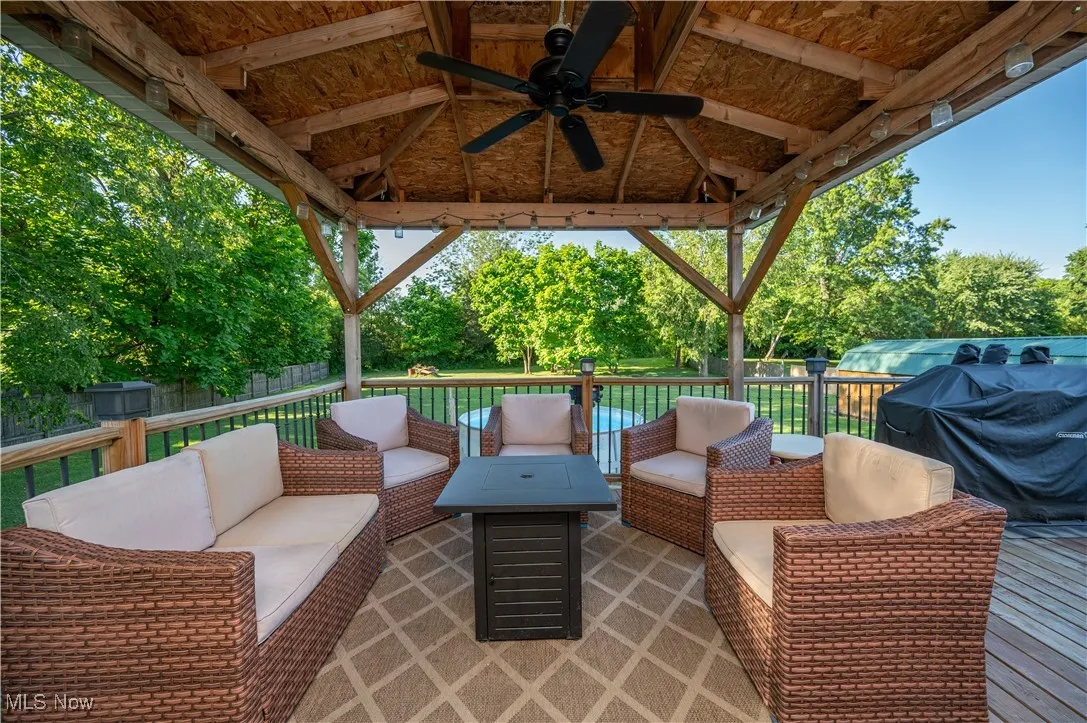 View of patio with an outdoor hangout area, a ceiling fan, a deck, and a gazebo
