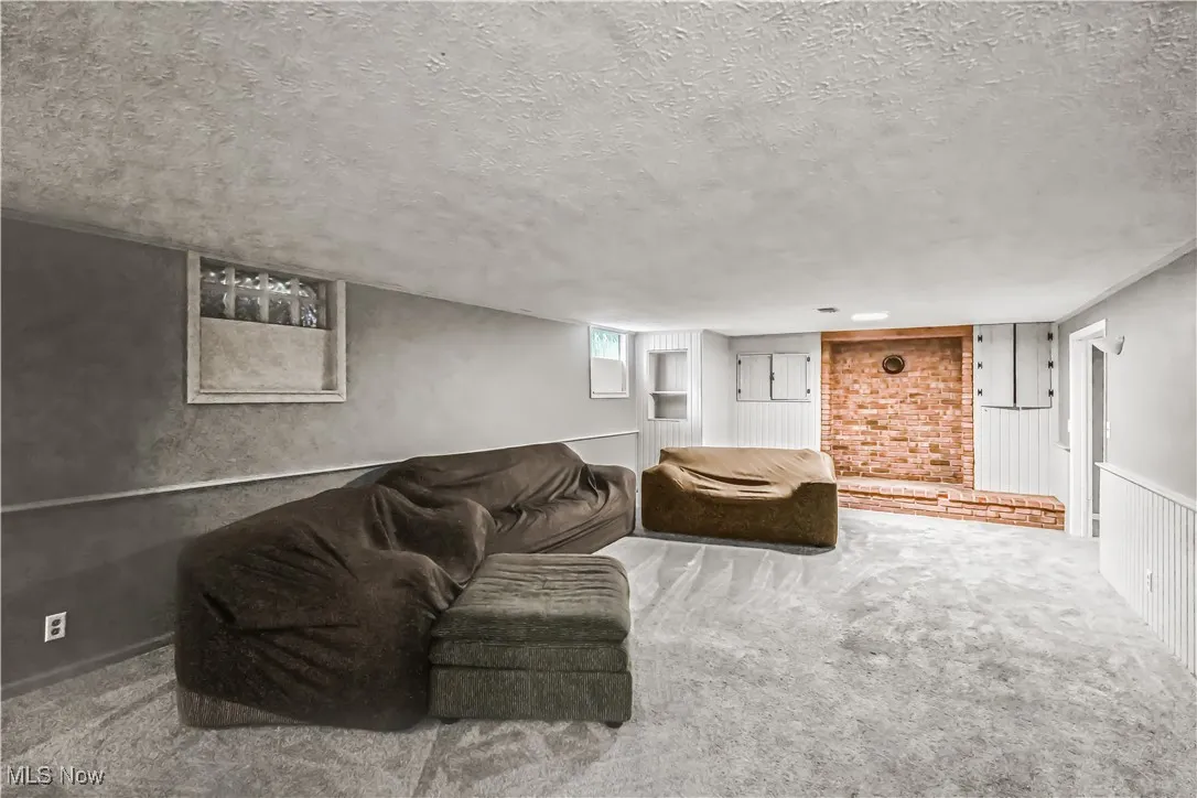 Living area with carpet flooring and a textured ceiling