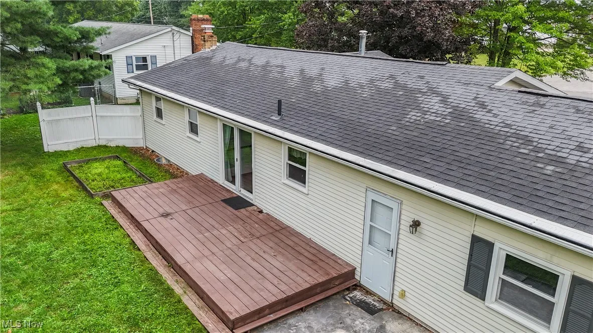 Back of property featuring roof with shingles and a deck