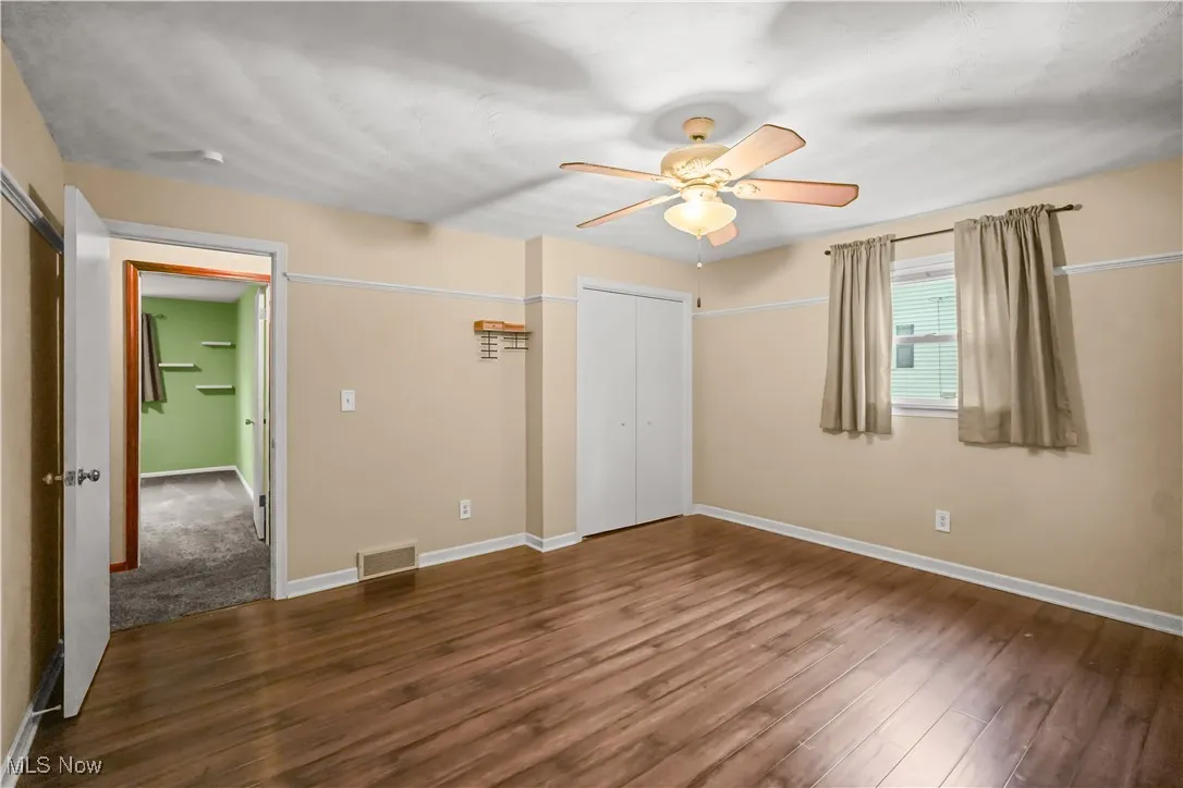 Unfurnished bedroom with wood finished floors and a ceiling fan