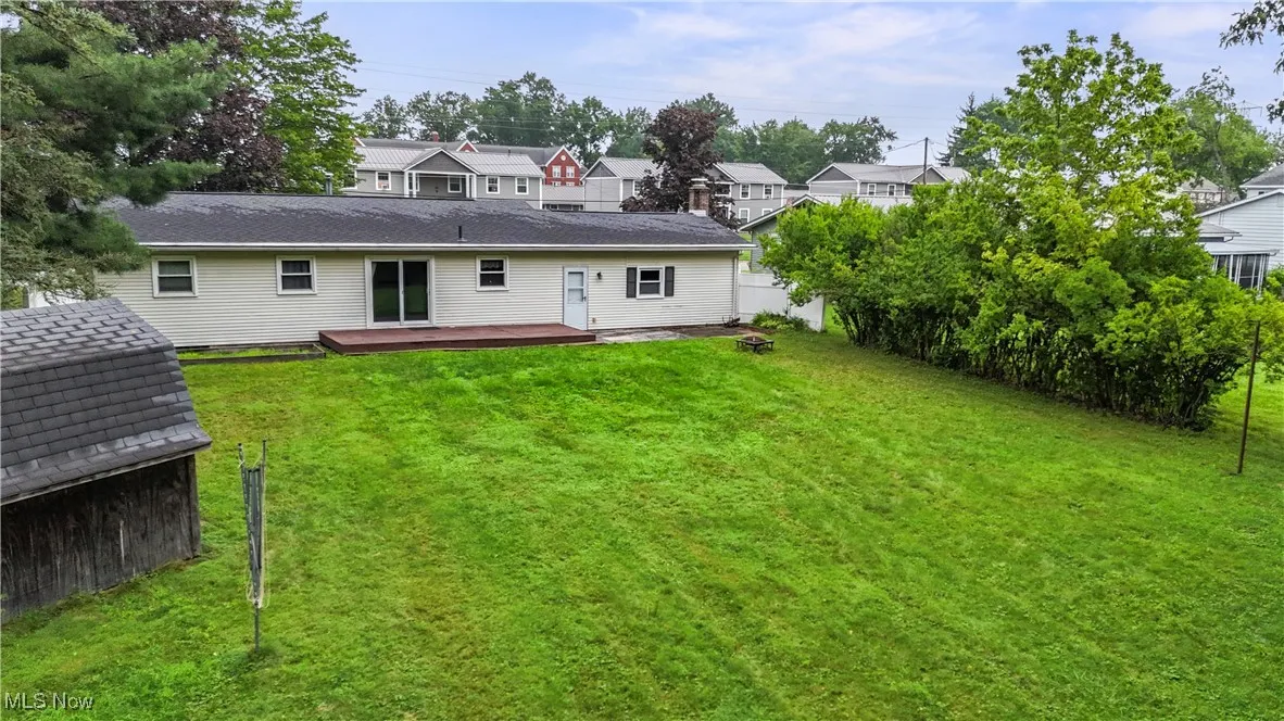 Back of property with a wooden deck and a residential view