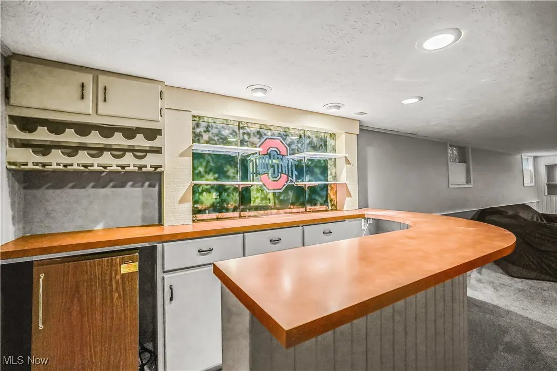 Bar with a textured ceiling, carpet, and recessed lighting