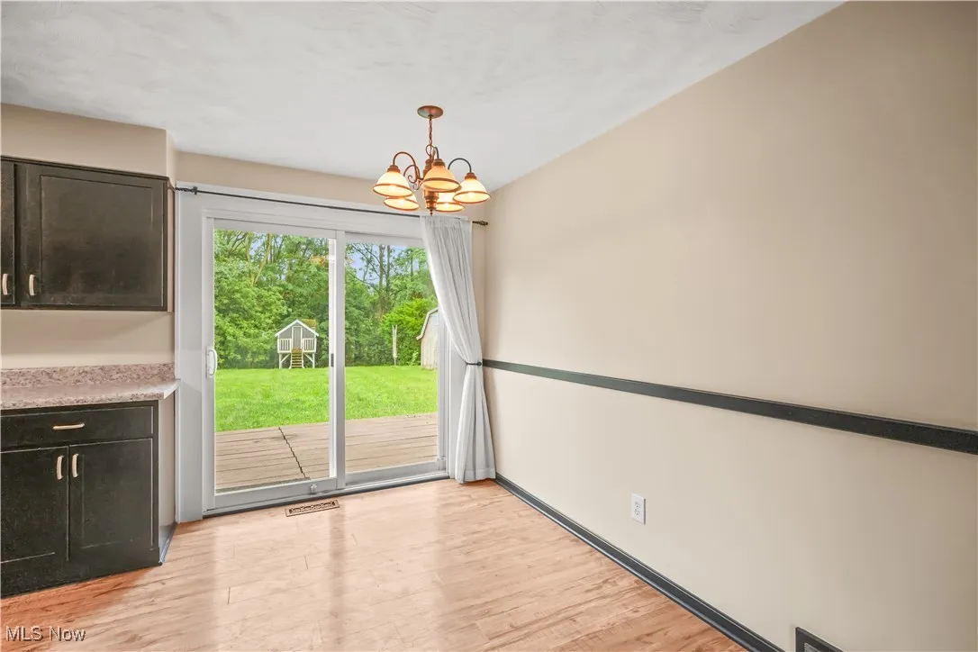 Unfurnished dining area featuring light wood-style floors and a chandelier
