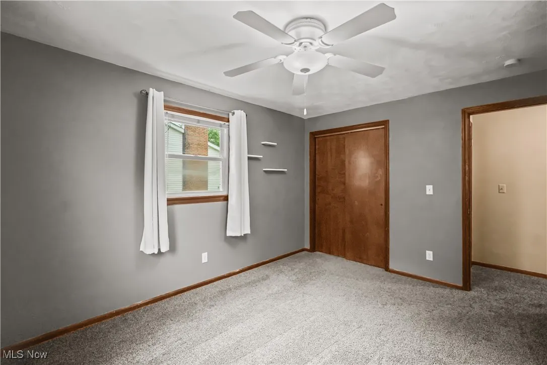 Unfurnished bedroom featuring carpet floors, a closet, and a ceiling fan