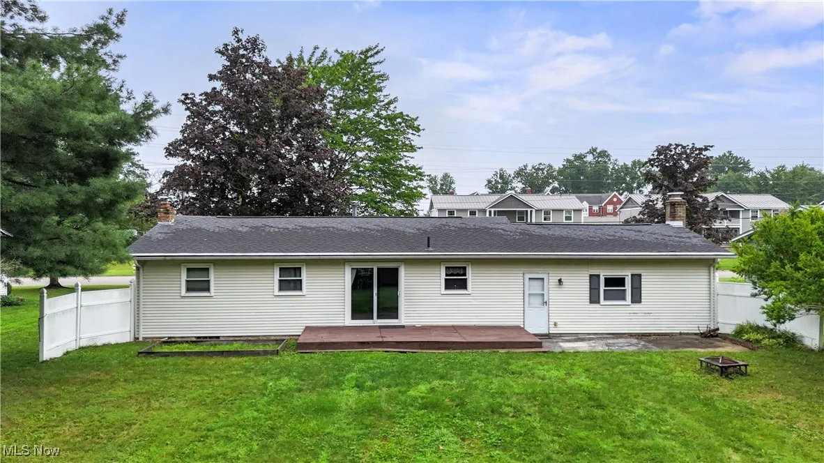 Rear view of house featuring a chimney, a deck, an outdoor fire pit, and a shingled roof
