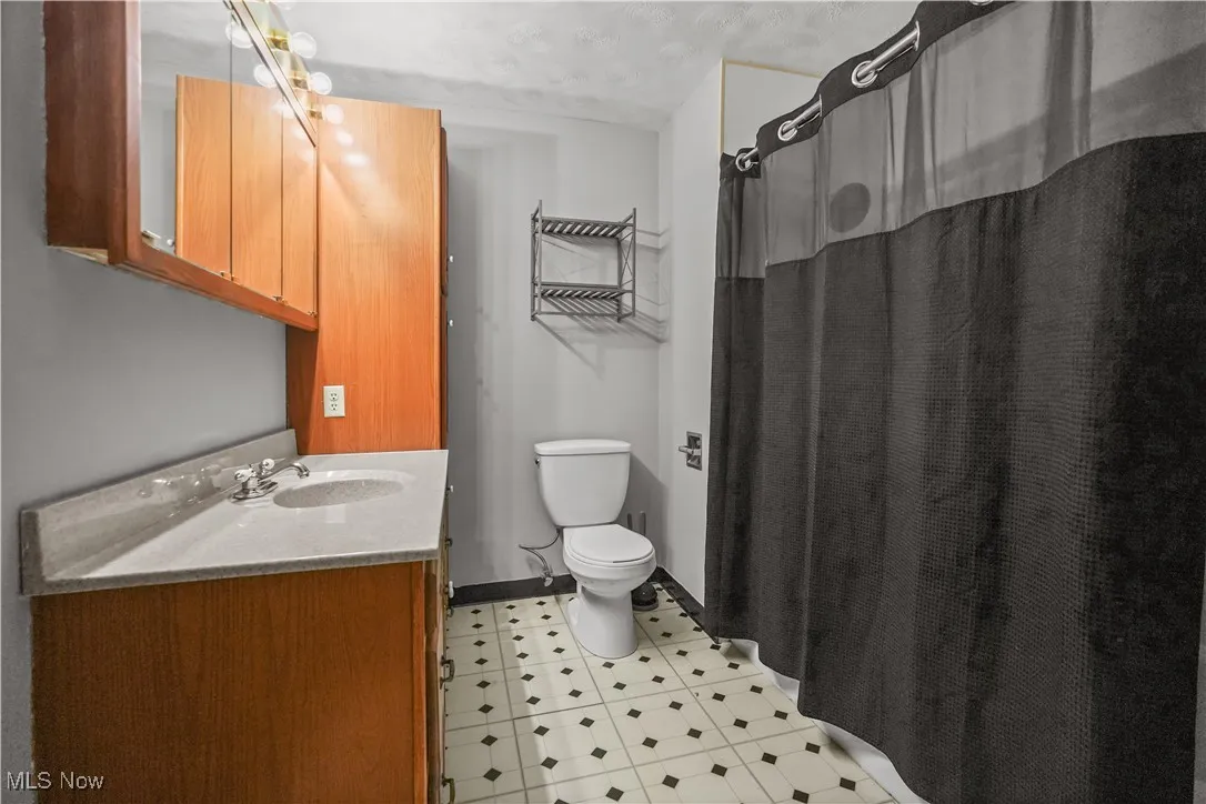 Bathroom with vanity, tile patterned floors, and curtained shower