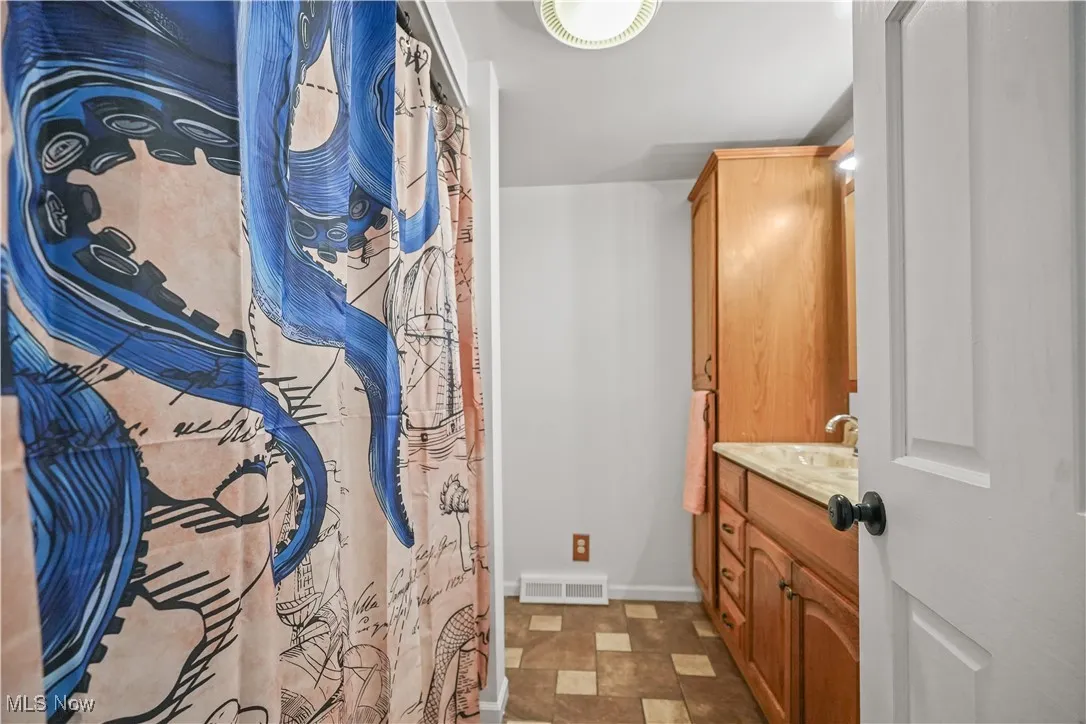 Full bath with vanity and baseboards