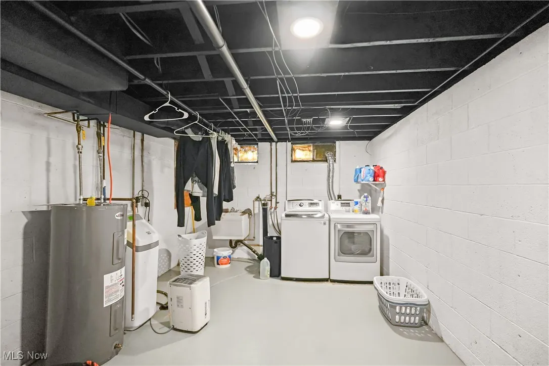 Below grade area with independent washer and dryer, water heater, and a water softener