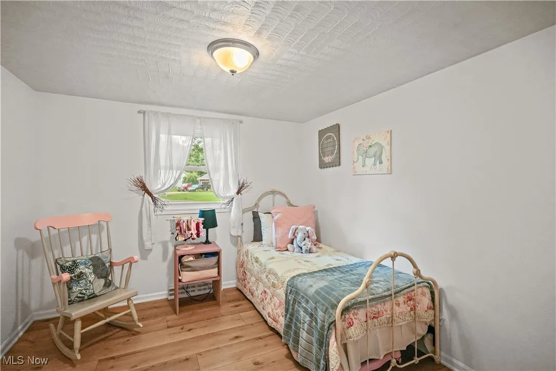 Bedroom with wood finished floors and baseboards
