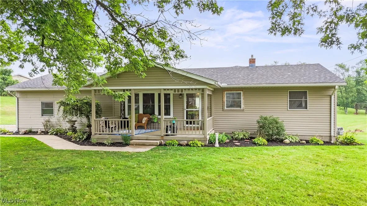 Back of property featuring a shingled roof, a lawn, and a chimney
