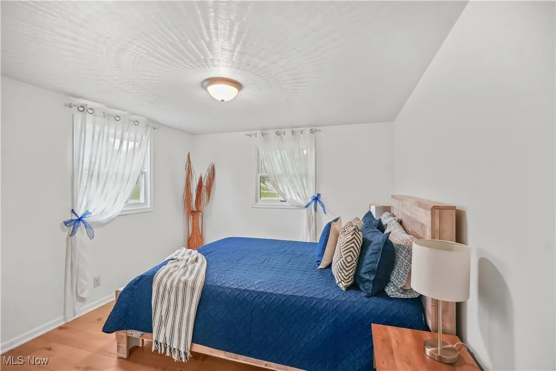 Bedroom with wood finished floors and baseboards