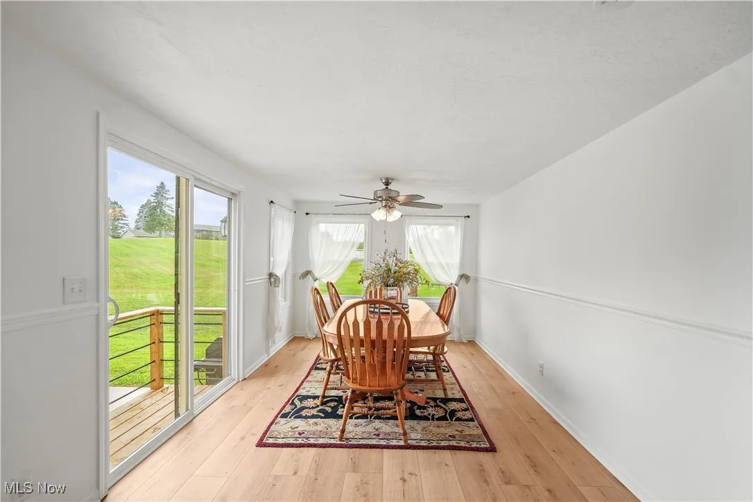Dining room with light wood finished floors and ceiling fan