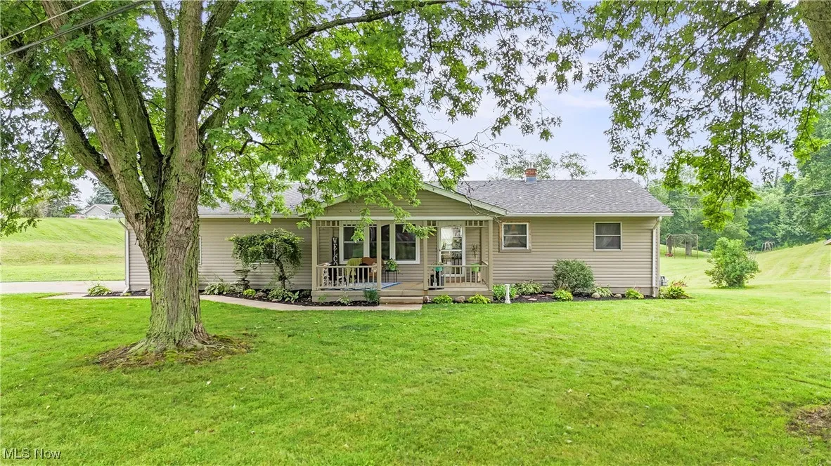 Ranch-style house with a porch, a front yard, and a chimney
