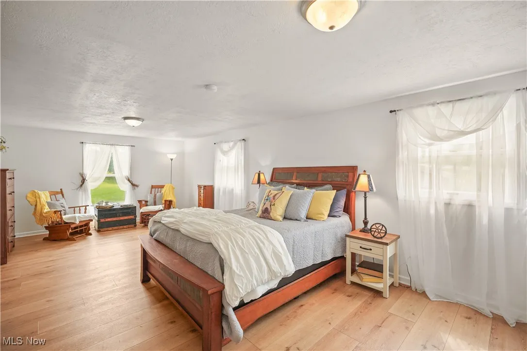 Bedroom featuring light wood-type flooring and a textured ceiling