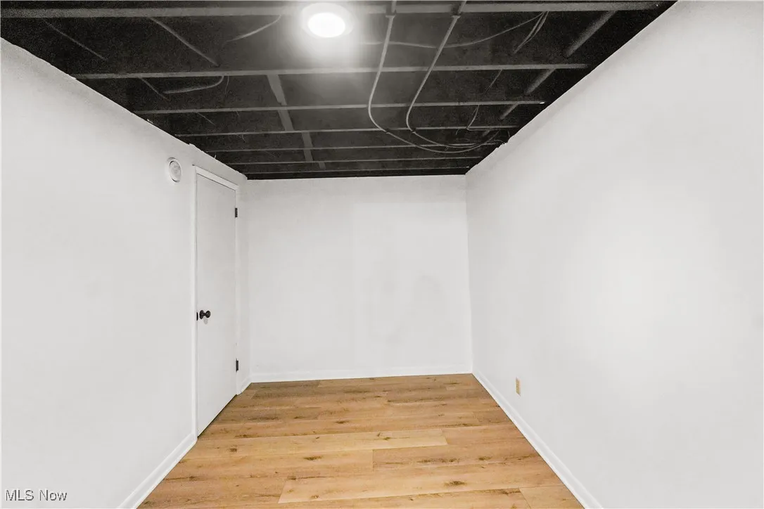 Finished below grade area with light wood-style floors and baseboards