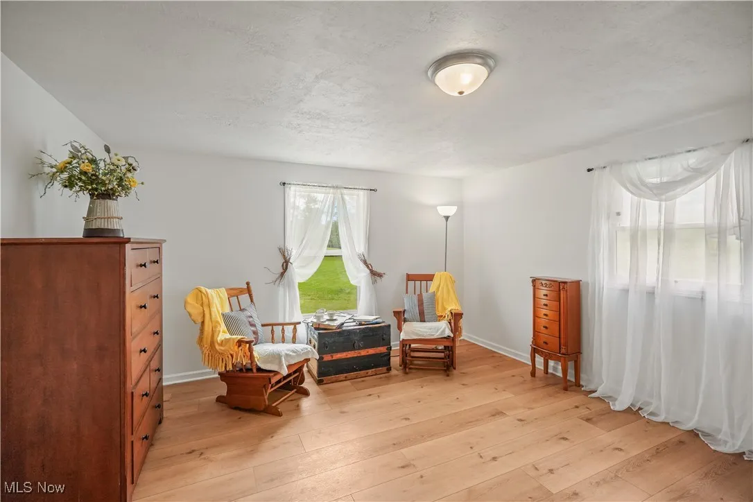 Sitting room featuring light wood-style flooring and a textured ceiling