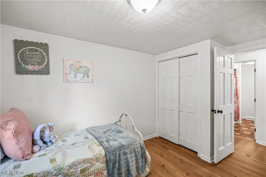Bedroom featuring wood-type flooring, a closet, and a textured ceiling