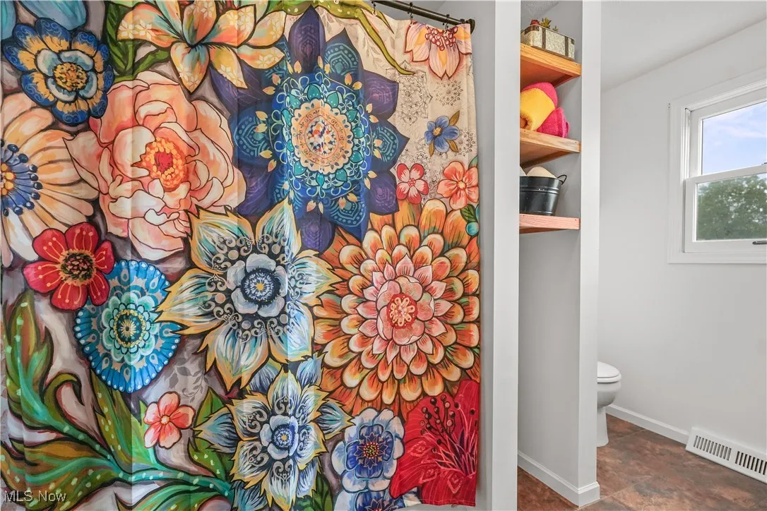 Bathroom with toilet and a shower with curtain
