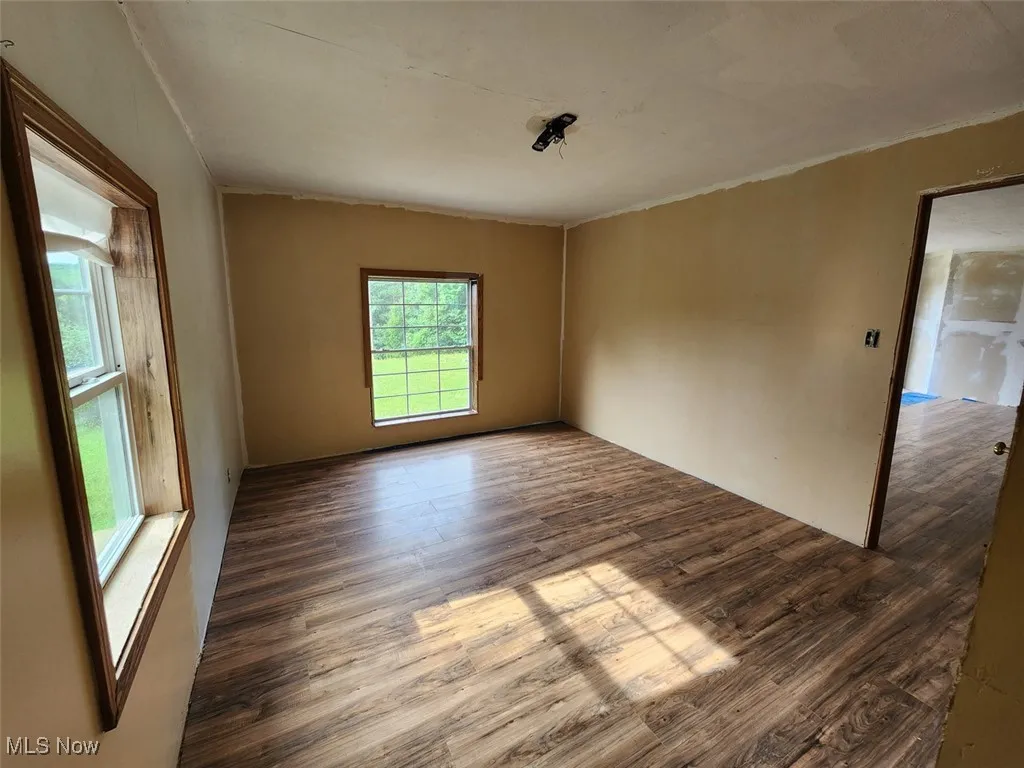 Spare room with dark wood-style floors and ornamental molding