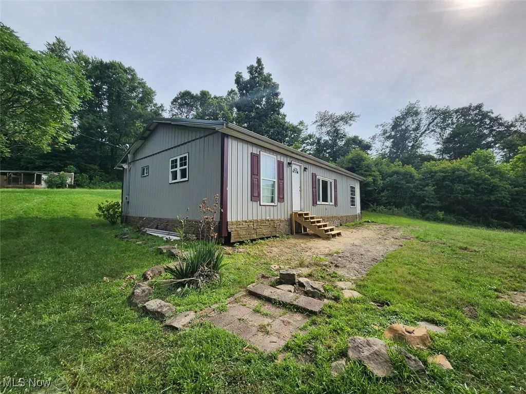 Manufactured / mobile home with entry steps, a front yard, and crawl space