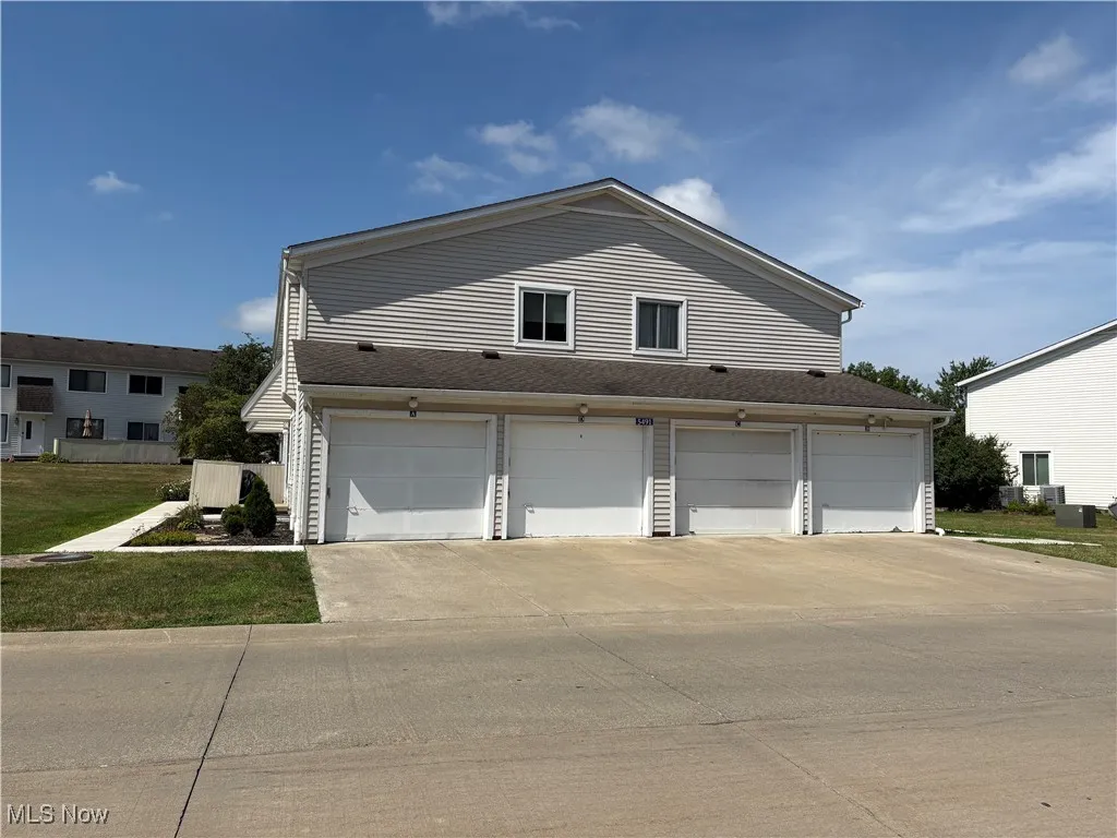 Concrete driveway and a garage. Home is on the left in rear. Garage is second from left