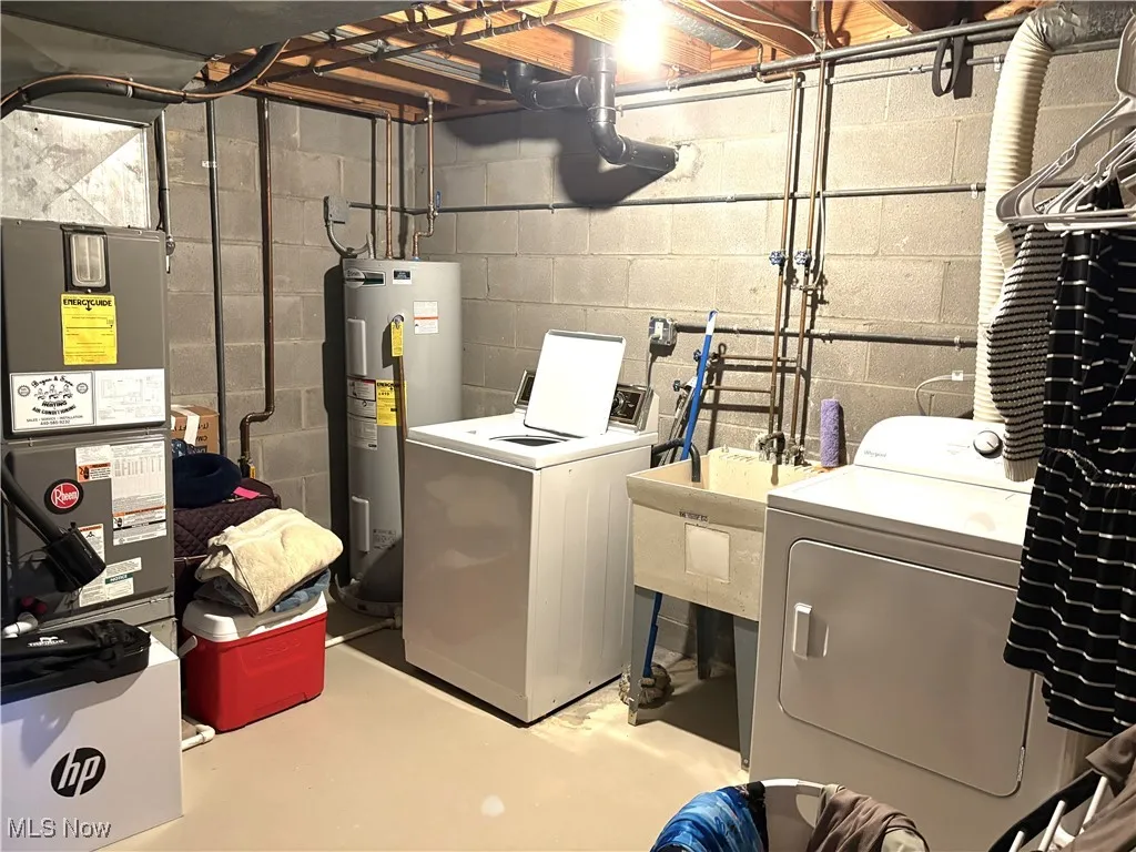 Laundry area featuring washing machine and clothes dryer. Storage room too