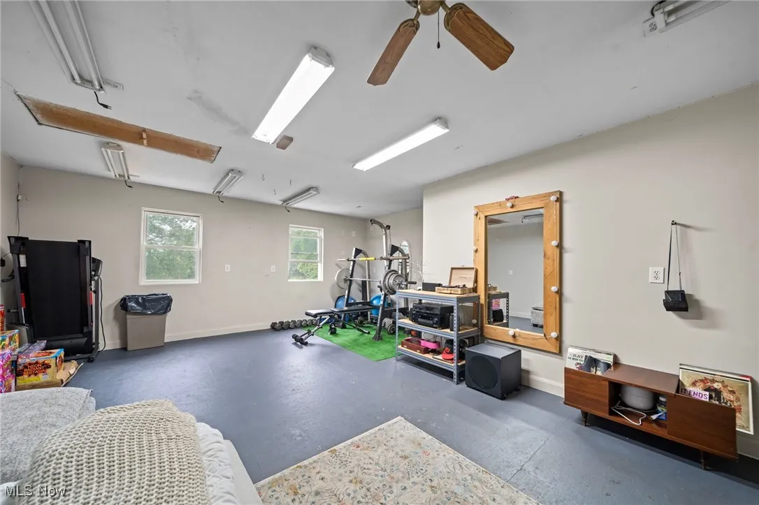 Exercise area featuring baseboards and a ceiling fan