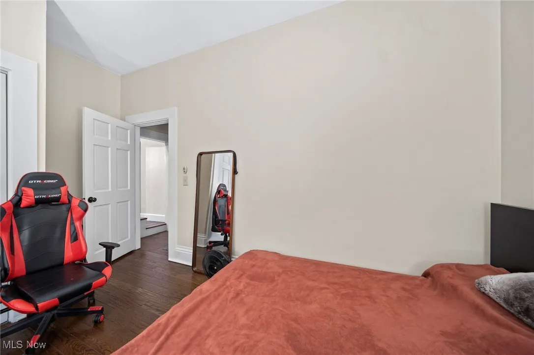 Bedroom with dark wood-type flooring and baseboards