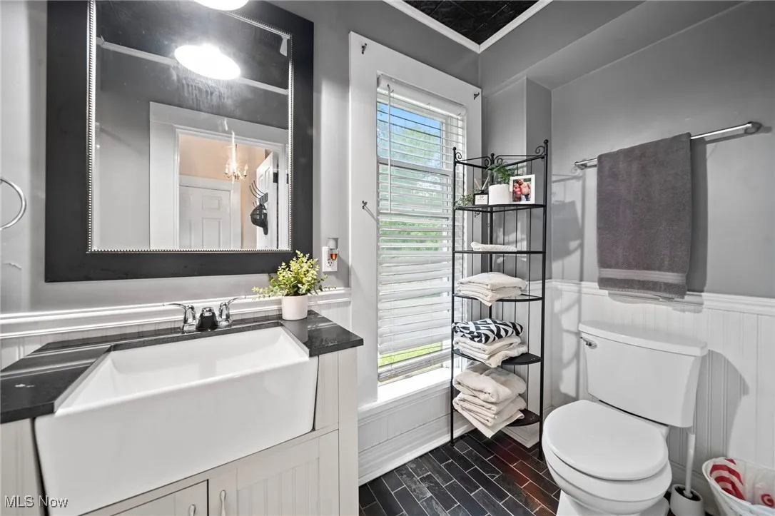 Bathroom with vanity, wainscoting, and wood finish floors