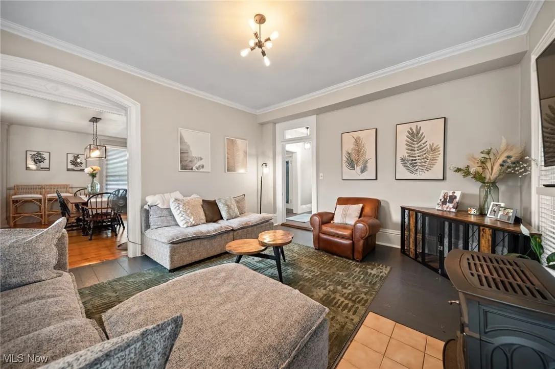 Living room with a chandelier, crown molding, and tile patterned flooring