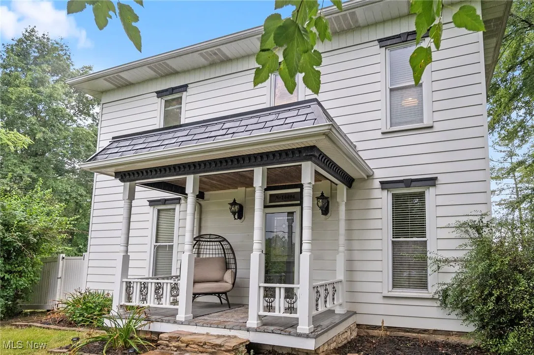 Doorway to property featuring covered porch