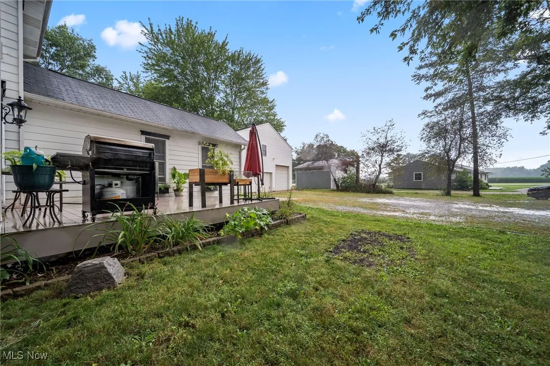 View of grassy yard with a wooden deck