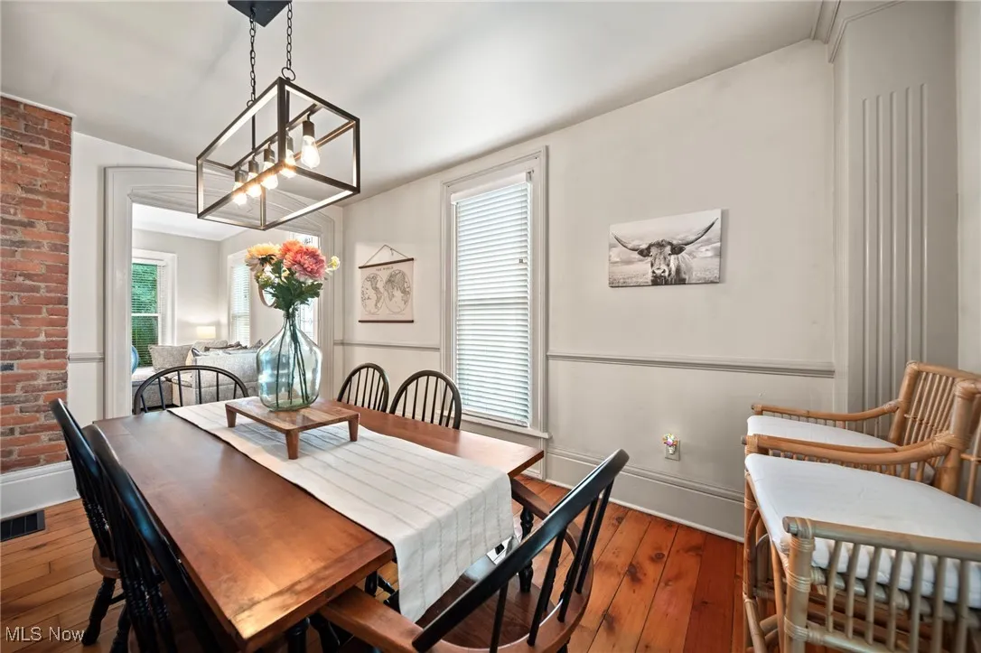 Dining area featuring wood-type flooring, a chandelier, and plenty of natural light
