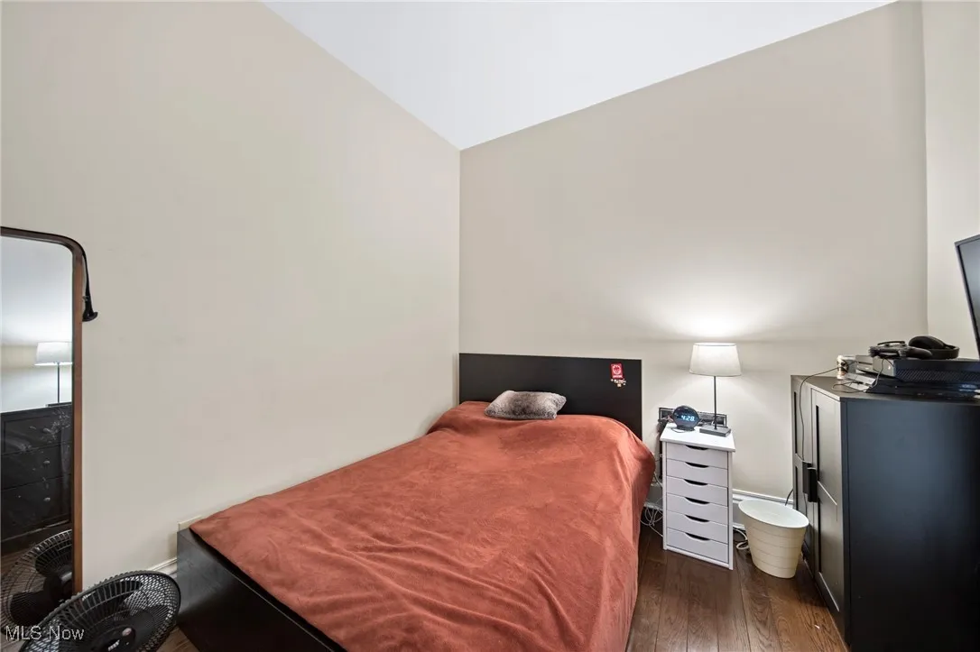 Bedroom with wood finished floors and vaulted ceiling