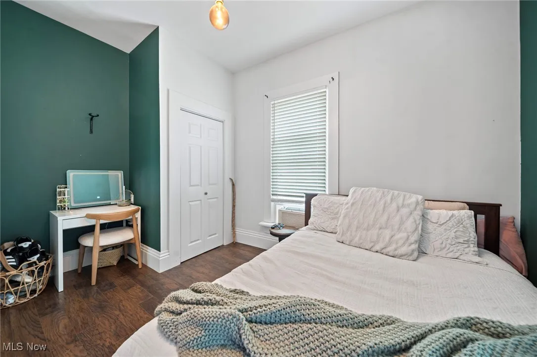 Bedroom with wood finished floors and a closet